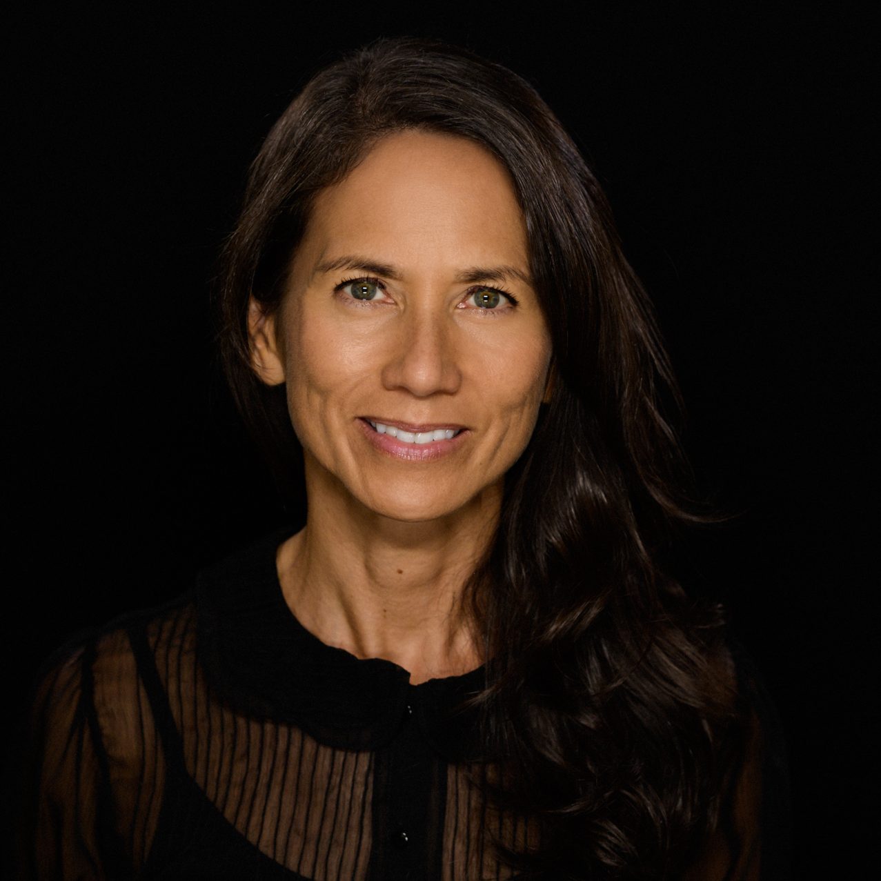 Female headshot on a pure black background.