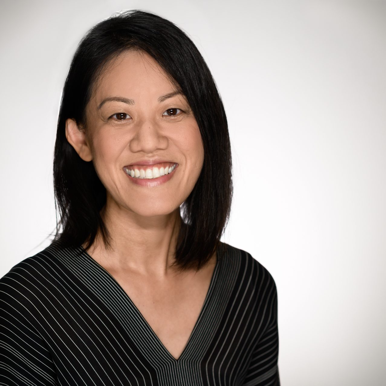 Female headshot on a white to gray background.